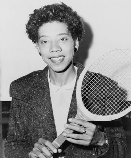 Althea Gibson, in a tweed suit, poses with her tennis racket