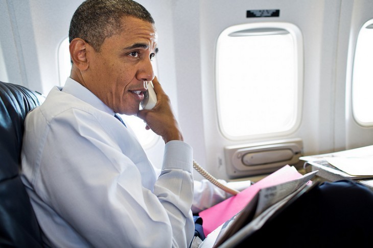 A photo of Barack Obama on the phone by an Air Force One window