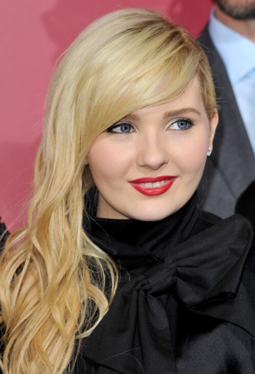 A photo of Abigail Breslin looking much sleeker and older, with tumbling blonde hair and red lipstick