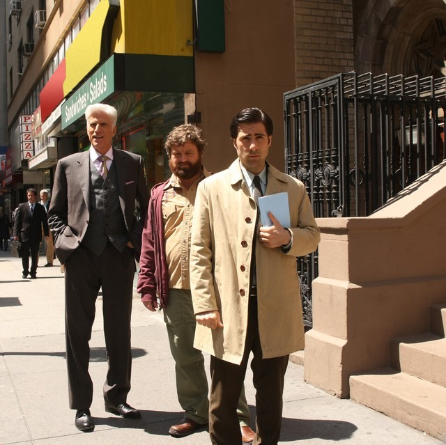 A photo of Jason Schwartzman in a trenchcoat on a city street, flanked by natty Ted Danson and scruffy Zach Gaifianakis