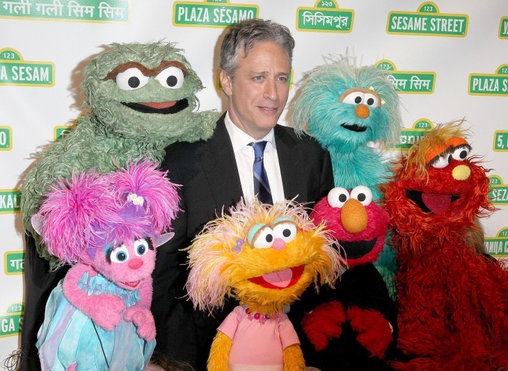Photo of Jon Stewart surrounded by Muppets in various colors and eyeball sizes