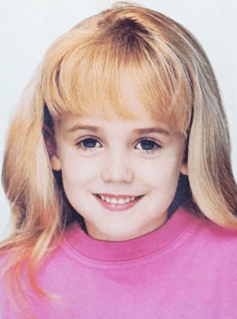 Photo of JonBenet Ramsey for a beauty competition, in a pink sweater, smiling
