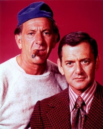 Photo of Jack Klugman in a baseball cap and with a cigar, and Tony Randall in a prim suit