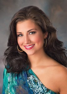 Laura Kaeppeler smiles for the camera in an aqua gown and brown hair