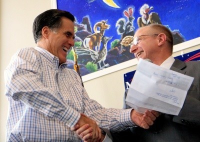 Photo of Mitt Romney laughing heartily as he shakes the hand of a Republican supporter
