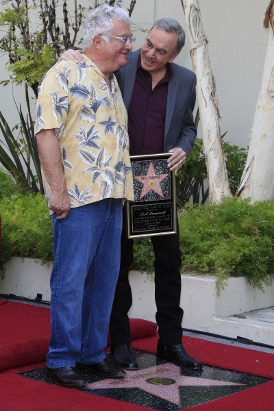 Photo of Neil Diamond hugging Randy Newman over a Hollywood star