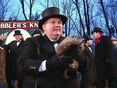 Photo of groundhog Punxsutawney Phil being held by a man in a top hat