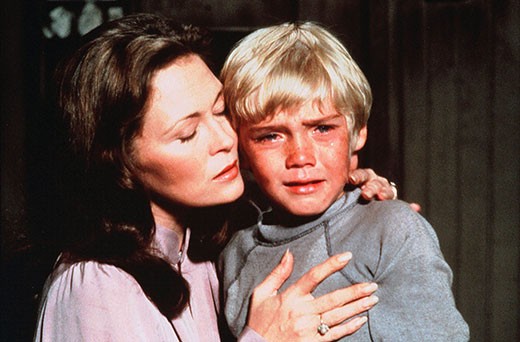 A photo of Ricky Schroeder crying and being comforted by his mother