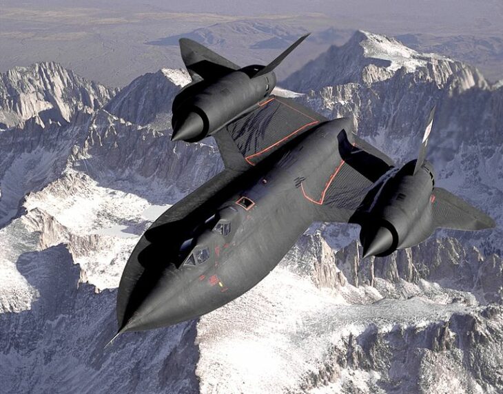 SR-71 photo, of a black spy plane soaring over snow-capped mountains