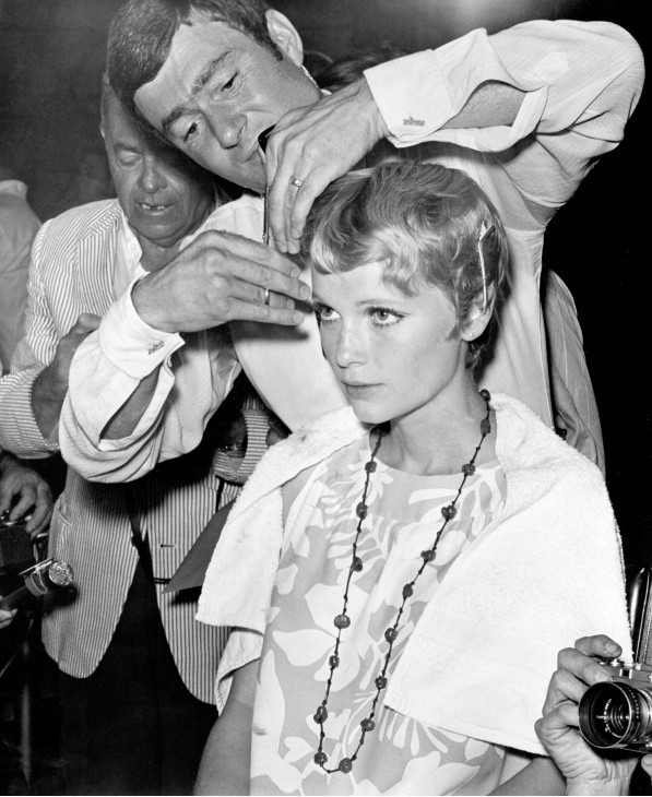 A photo of Vidal Sassoon behind Mia Farrow, trimming her hair intently