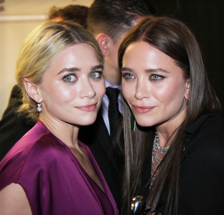 Ashley looking wide-eyed and grimacing in purple velvet, with Mary-Kate 