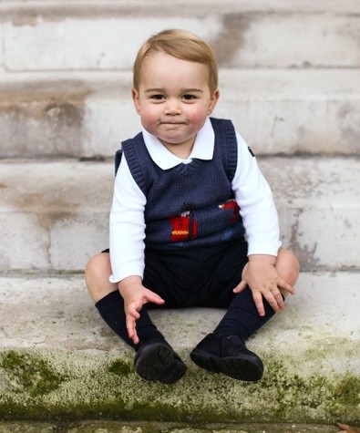 A photo of Prince George of Britain, a pudgy type in a blue sweater
