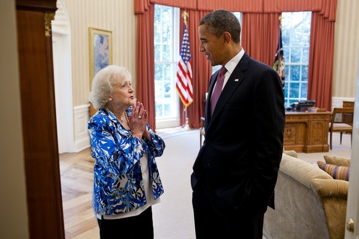 Photo of Betty White chatting with Barack Obama on the edge of the Oval Office