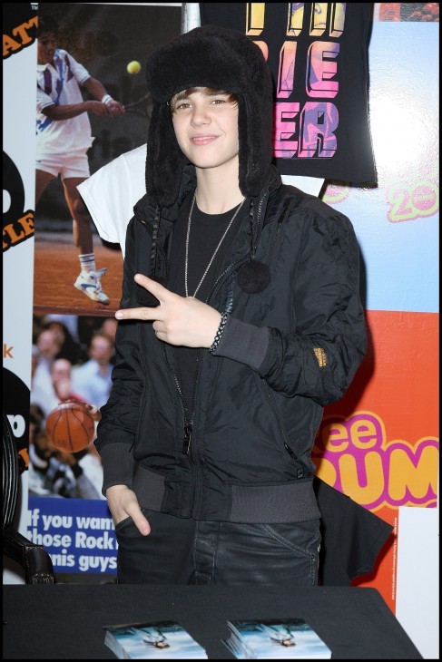 Photo of Justin Bieber waving to Parisian fans with a peace sign