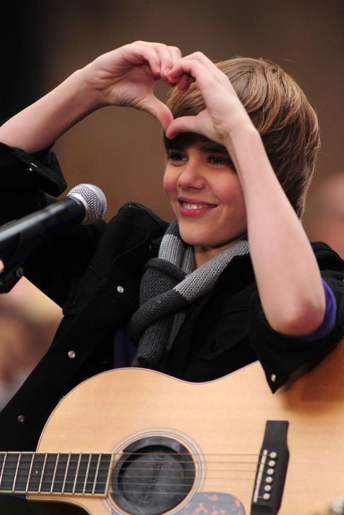 Photo of Justin Bieber holding his hands up together in the shape of a heart