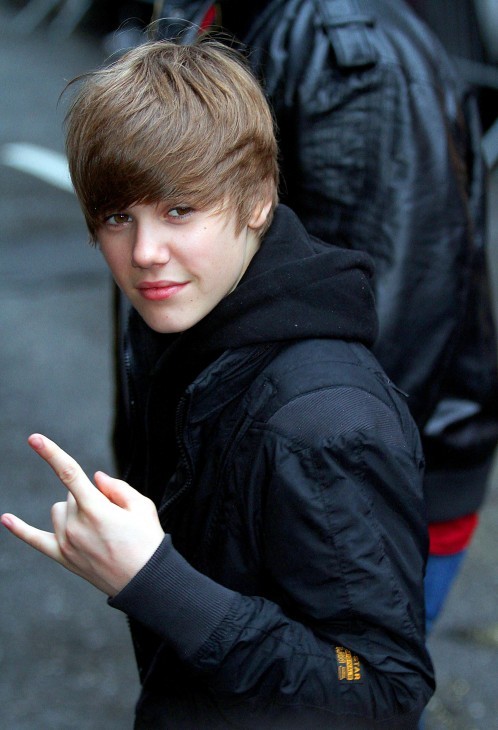 Photo of Justin Bieber throwing a hand signal to fans, with index finger and pinky extended