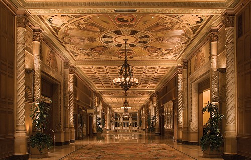 Photo of a glossy lobby with marble pillars and gold leaf