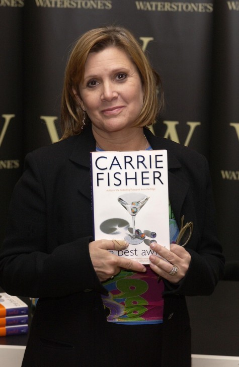 A photo of 'Star Wars' actress Carrie Fisher holding up a book reading, in big letters, CARRIE FISHER