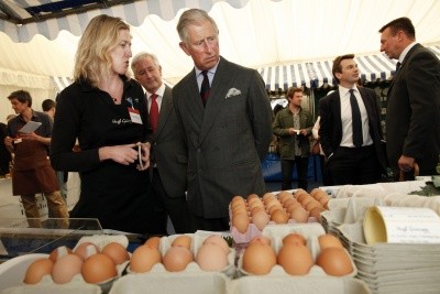 Photo of Prince Charles looking at boxes of brown eggs at a sustainable farming festival