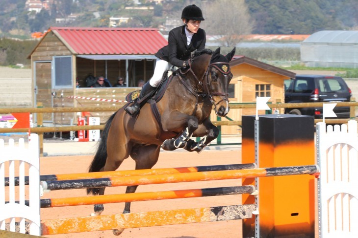 Charlotte Casiraghi photo on a horse leaping over a three-bar fence