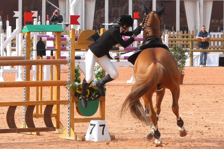 Photo of Charlotte Casiraghi leaping awkwardly onto a horse in the middle of the ring