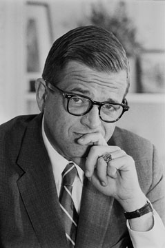 A photo of Chuck Colson, hand on chin, looking at the camera with a wry experession