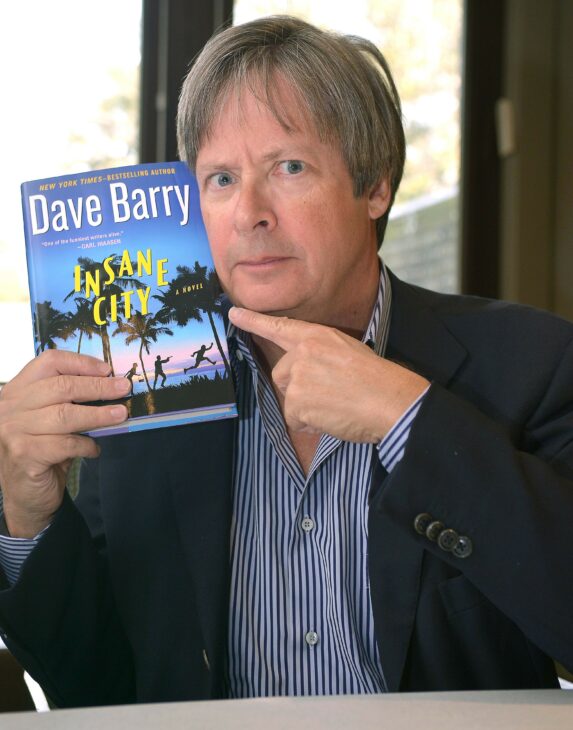 Photo of Dave Barry holding up his book 'Insane City'.