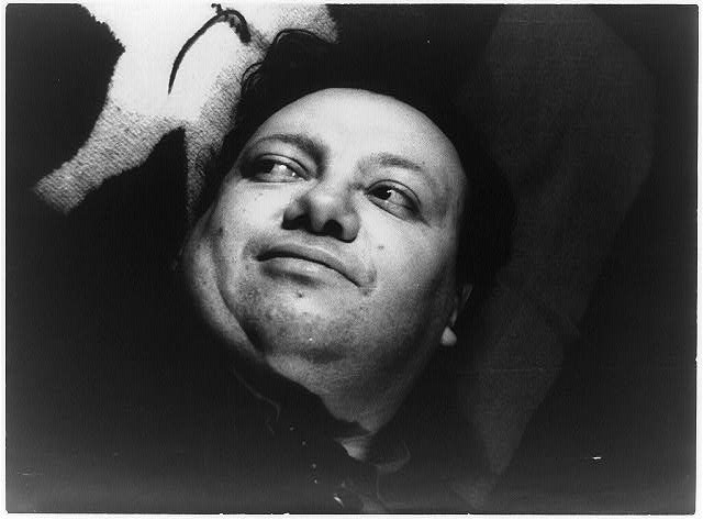 A photo of Diego Rivera, unshaven, looking up with a half-smile