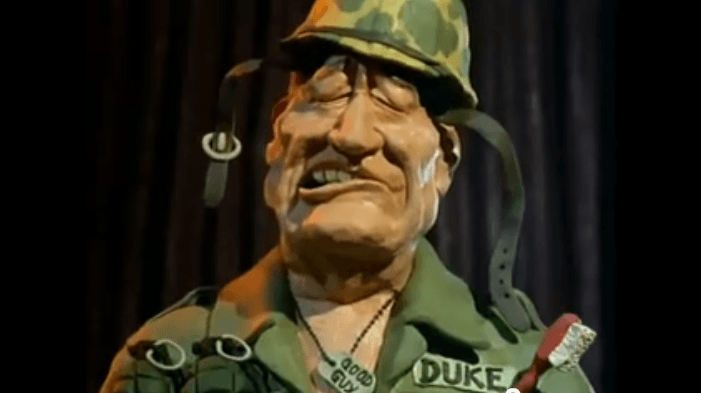 A claymation image of John Wayne, with dog tags reading 'Good Guy'