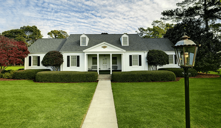 Photo of the Eisenhower Cabin at Augusta National, a tidy white house with black shutters amid green grass