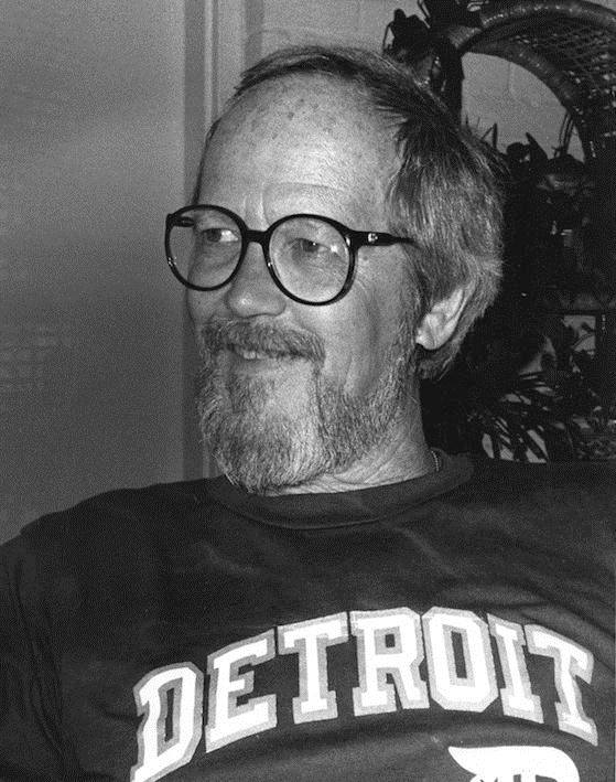 Photo of Elmore Leonard, looking younger, bearded and happy, in a 'Detroit' shirt