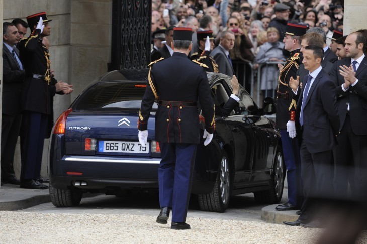 The car bearing Nicolas Sarkozy and Carla Bruni disappears through a gate and into crowds outside