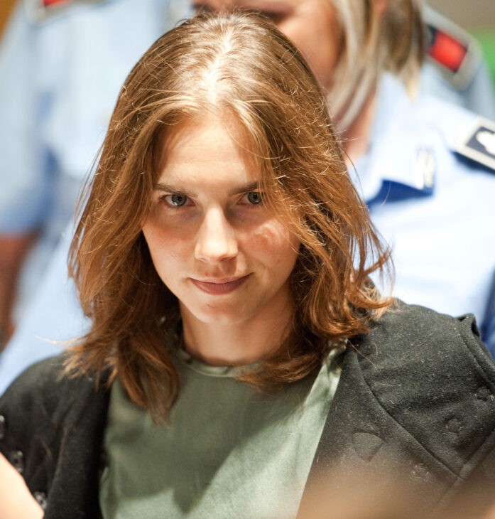 Photo of a grimly smiling Amanda Knox in courtroom