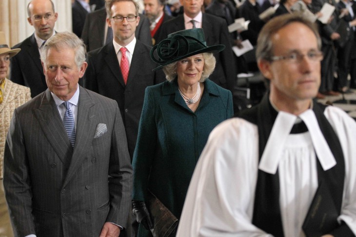 Photo of Prince Charles and Camilla in church dress, walking in a procession behind some bishops or clergy of some kind