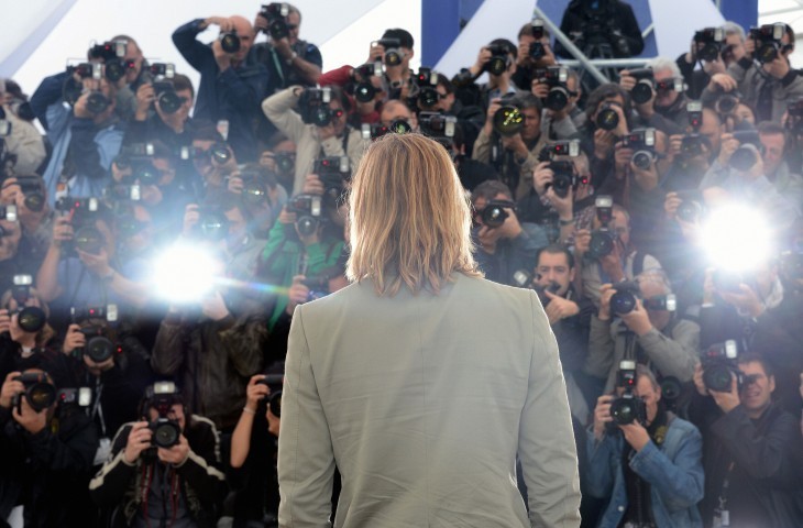 Brad Pitt photo, with him standing back to the camera in front of a horde of photogs