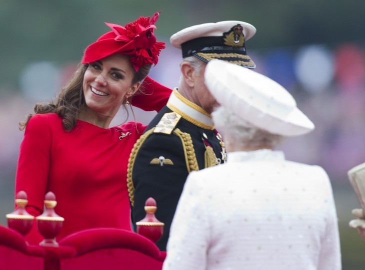 Photo of Kate Middleton smiling at the Queen, who is seen from behind