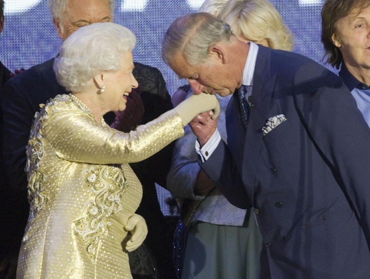 Photo of Prince Charles kissing the hand of Queen Elizabeth as she smiles