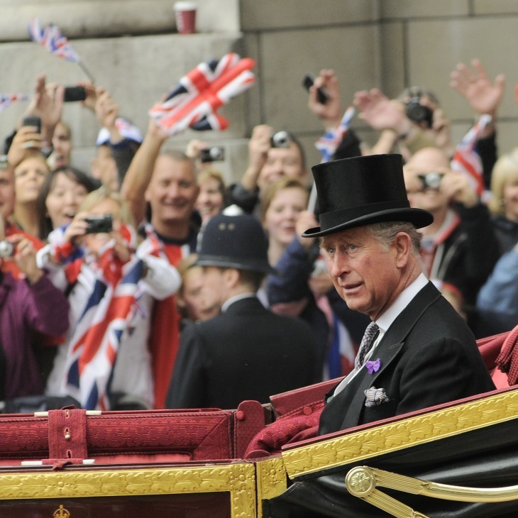 Photo of Prince Charles riding in a carriage in a parade-type situation