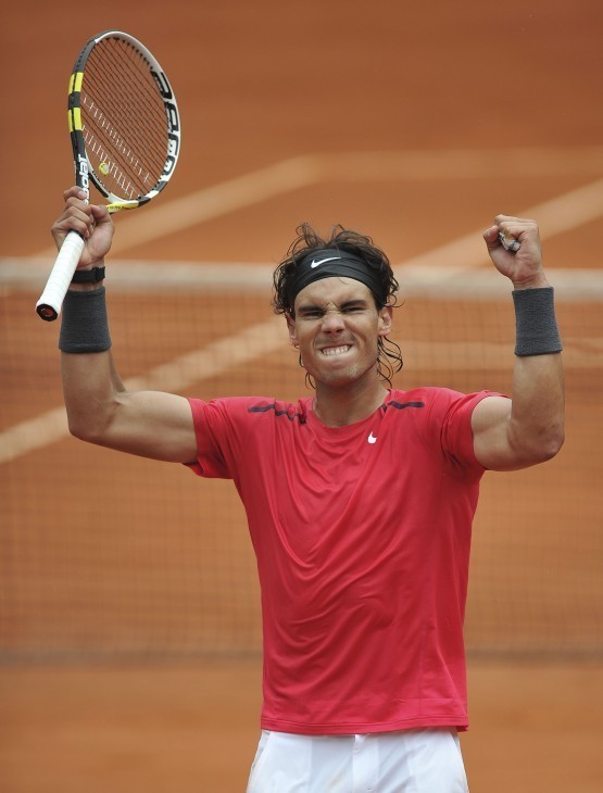 Photo of Rafael Nadal raising his arms with fists clenched after winning a point at the French Open