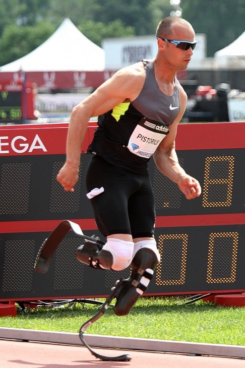 A photo of Oscar Pistorius running on his curved carbon-fiber blades with tiny spikes on the bottom 