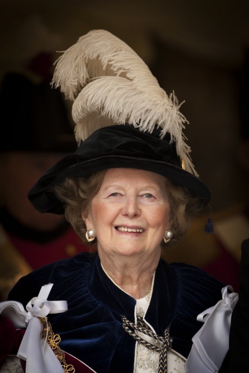 Margaret Thatcher photo with a large feather in her hat and an academic gown, smiling