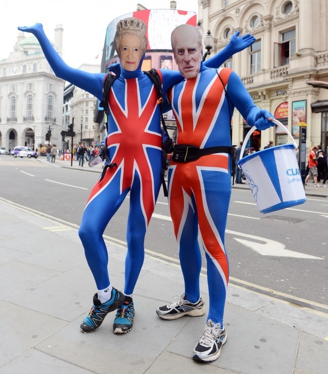 A couple wears Union Jack running tights (VERY tight) and masks of Elizabeth and Philip