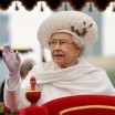 Photo of Queen Elizabeth in a white dress and scarf, waving to crowds
