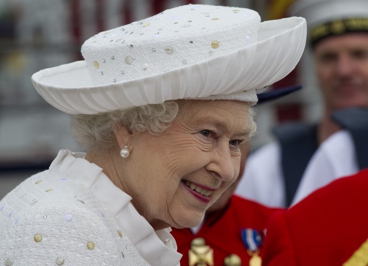 Photo of Queen Elizabeth, smiling on her barge, in a lovely white coat and hat