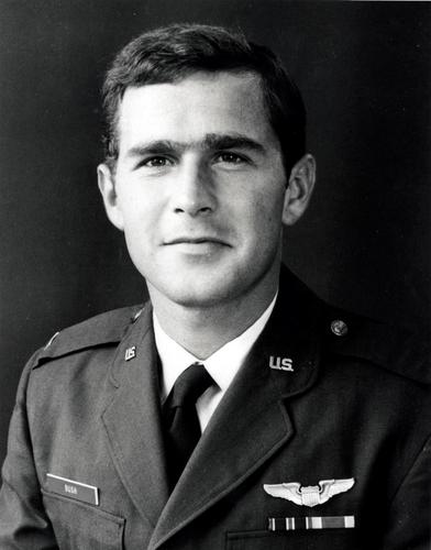 A photo of George W. Bush as a young man, in a military dress uniform, with wings and service bar on his chest