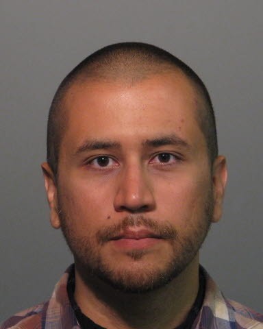 A mug shot of George Zimmerman, facing camera, with a slightly scruffy beard