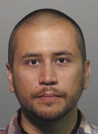 Mug shot of George Zimmerman, bewhiskered and looking vaguely unhappy