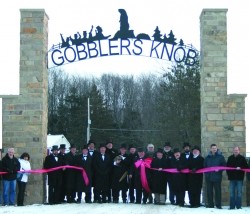 Photo of a big brick gate with an ironwork groundhog over the arch