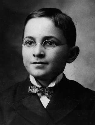 A photo of Harry Truman as a young boy, with round glasses and bow tie
