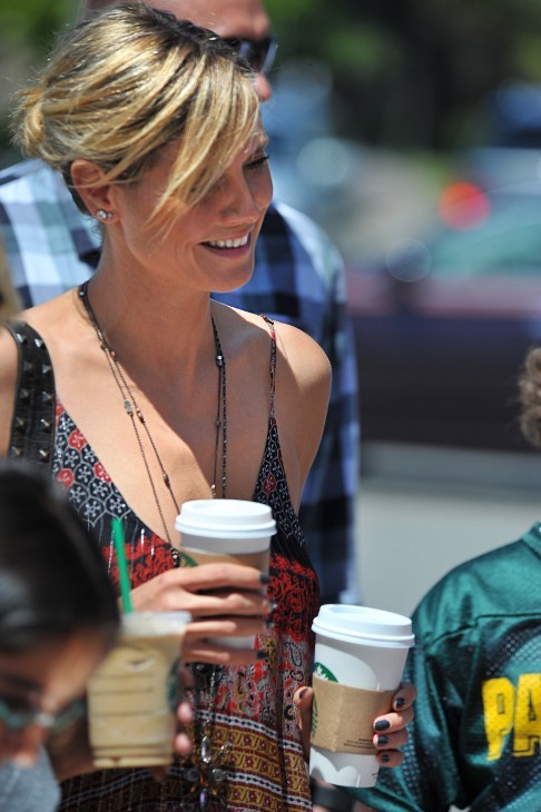 Heidi Klum photo, with Heidi Klum holding two cups of Starbucks coffee and smiling in a summer dress